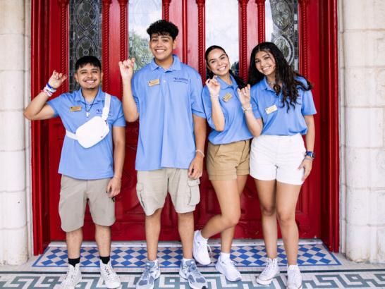 Orientation leaders standing in front of the red doors.