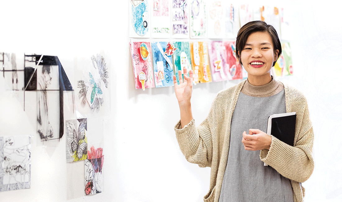 Visual Studies student standing in front of artwork.