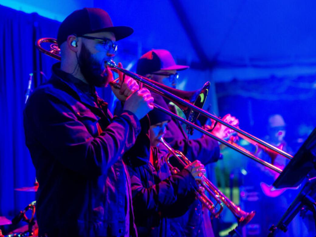 Brass musicians play their instruments at a concert.