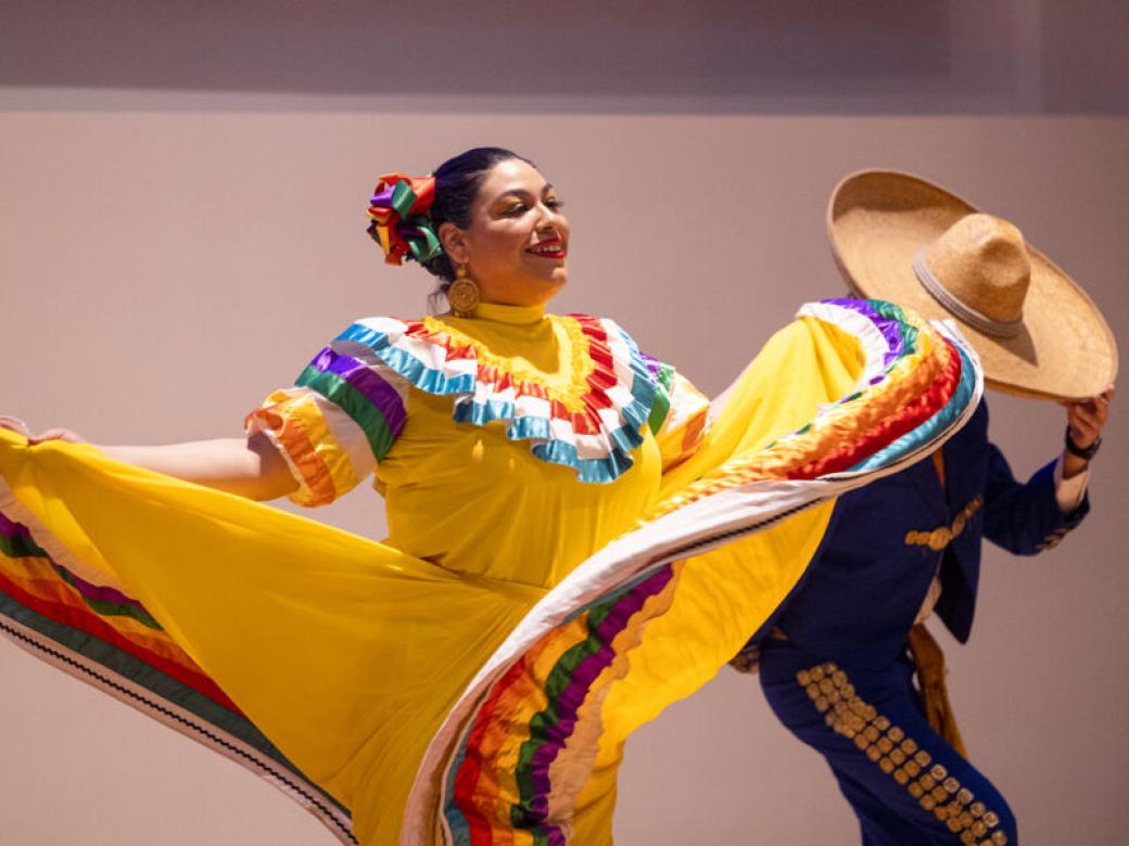 Two Ballet Folklorico performers dance in traditional dress.