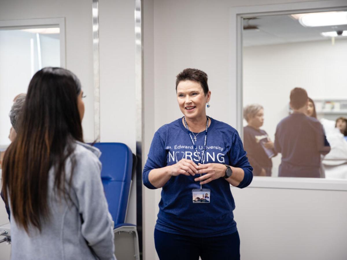 Donna Beuk talks to a student in the nursing labs