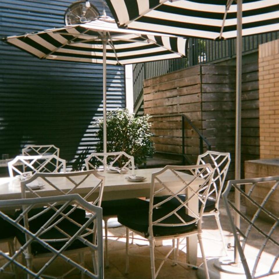 Patio seating at Josephine House, featuring black and white striped umbrellas.