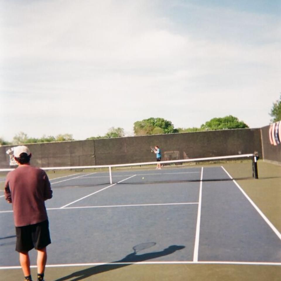 Students play tennis on the courts on campus.