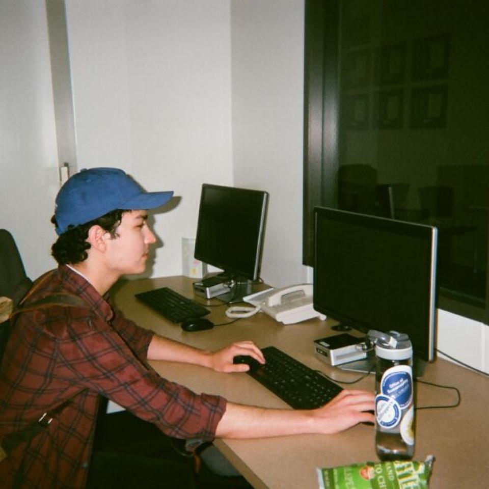 Alex Castillon works on a a computer on campus.