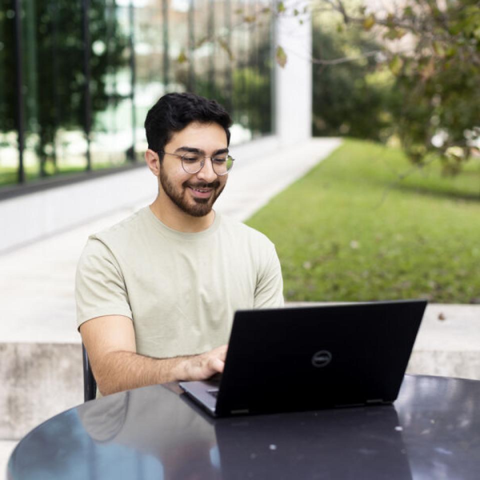 Student using his laptop on campus.