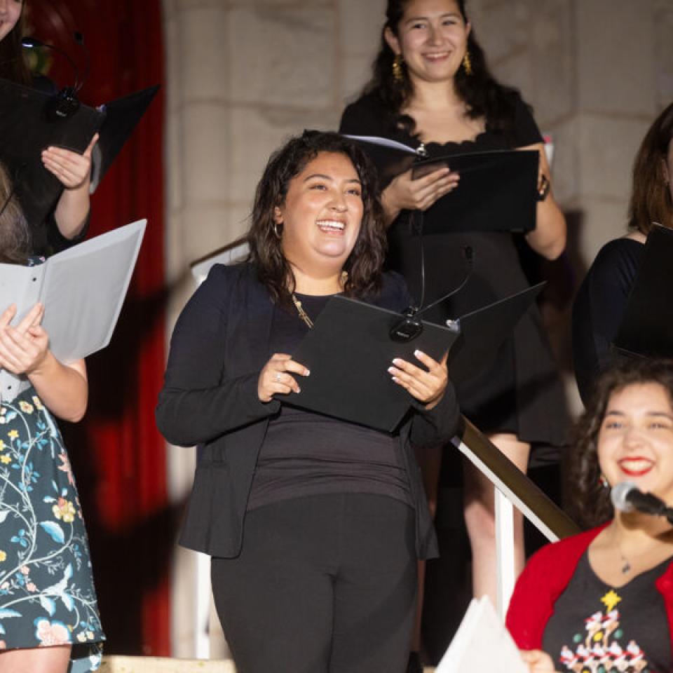 S group of 5 women holding songbooks singing christmas carols