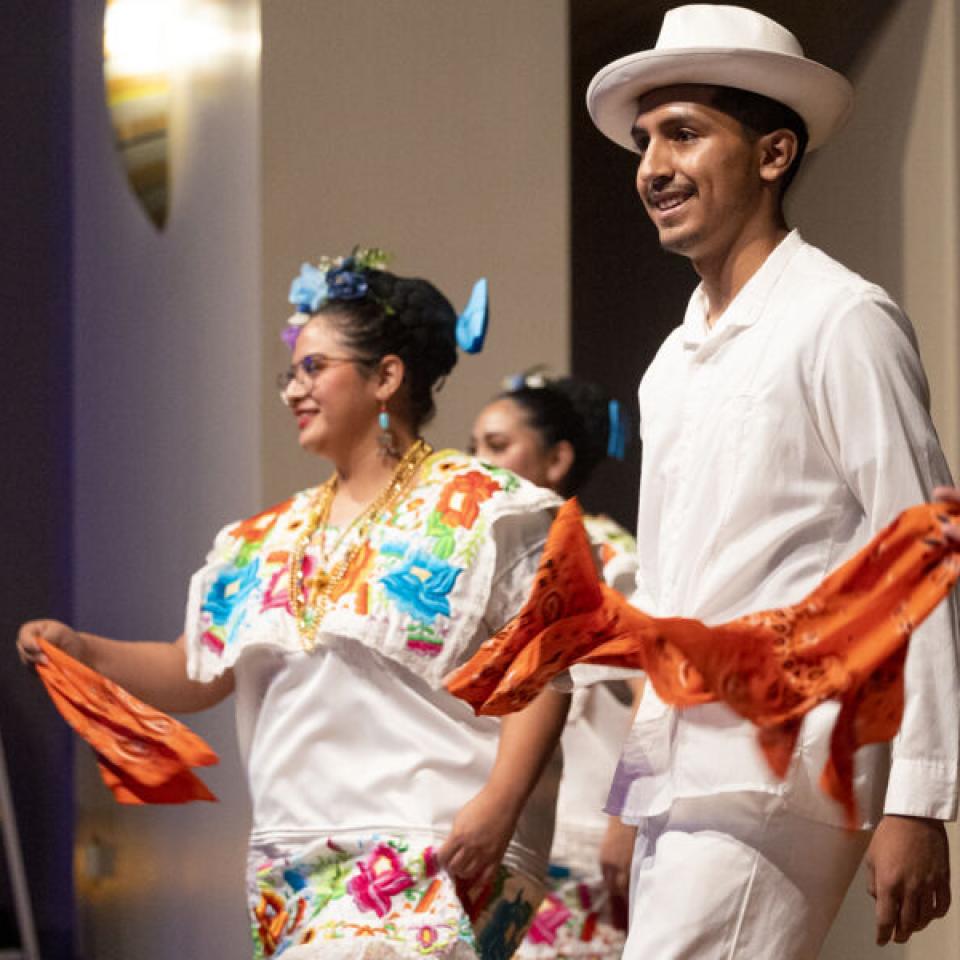 A man and a woman dancing, wearing colorful clothing