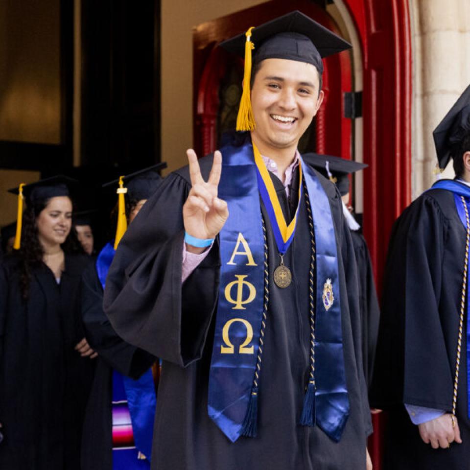 Graduating senior poses for a photo at commencement.