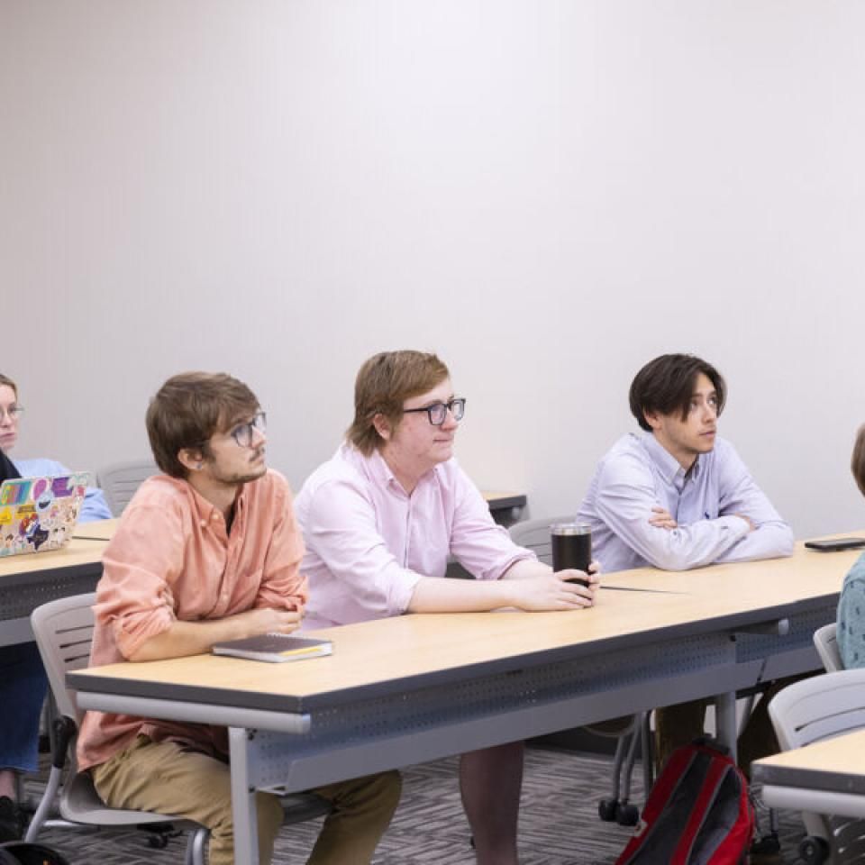 Students listening to their professor during a lecture in the classroom.