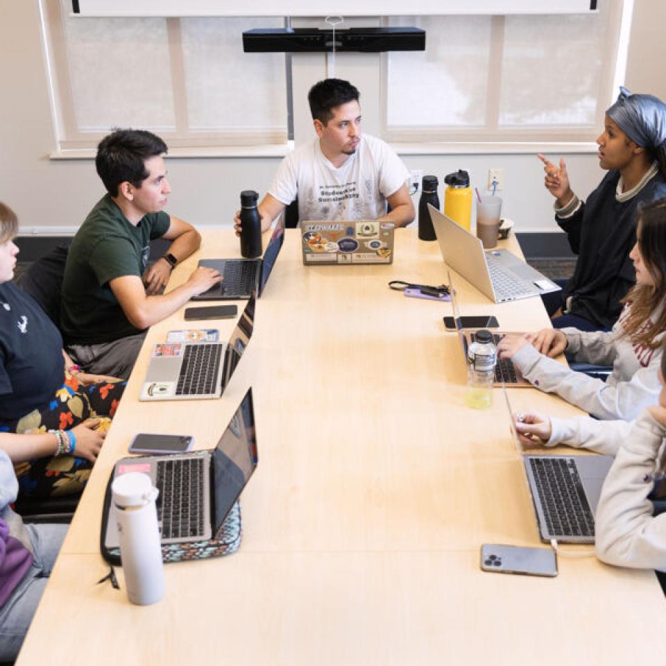 Ethan Tobias sits at the head of the table as he meets with six other students during a Big Event meeting.