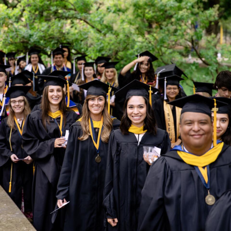 Graduating seniors lining up near the University Seal during commencement.