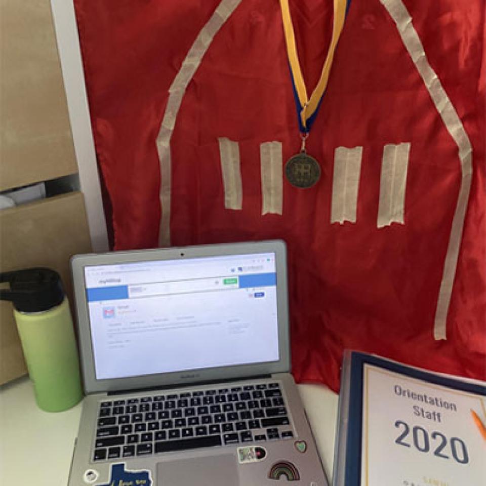 A laptop with a red door flag and medallion behind it.