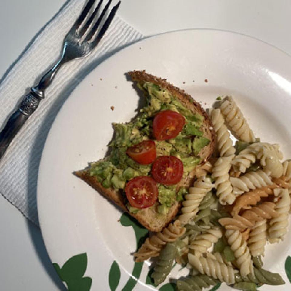 A plate of pasta and avocado toast.