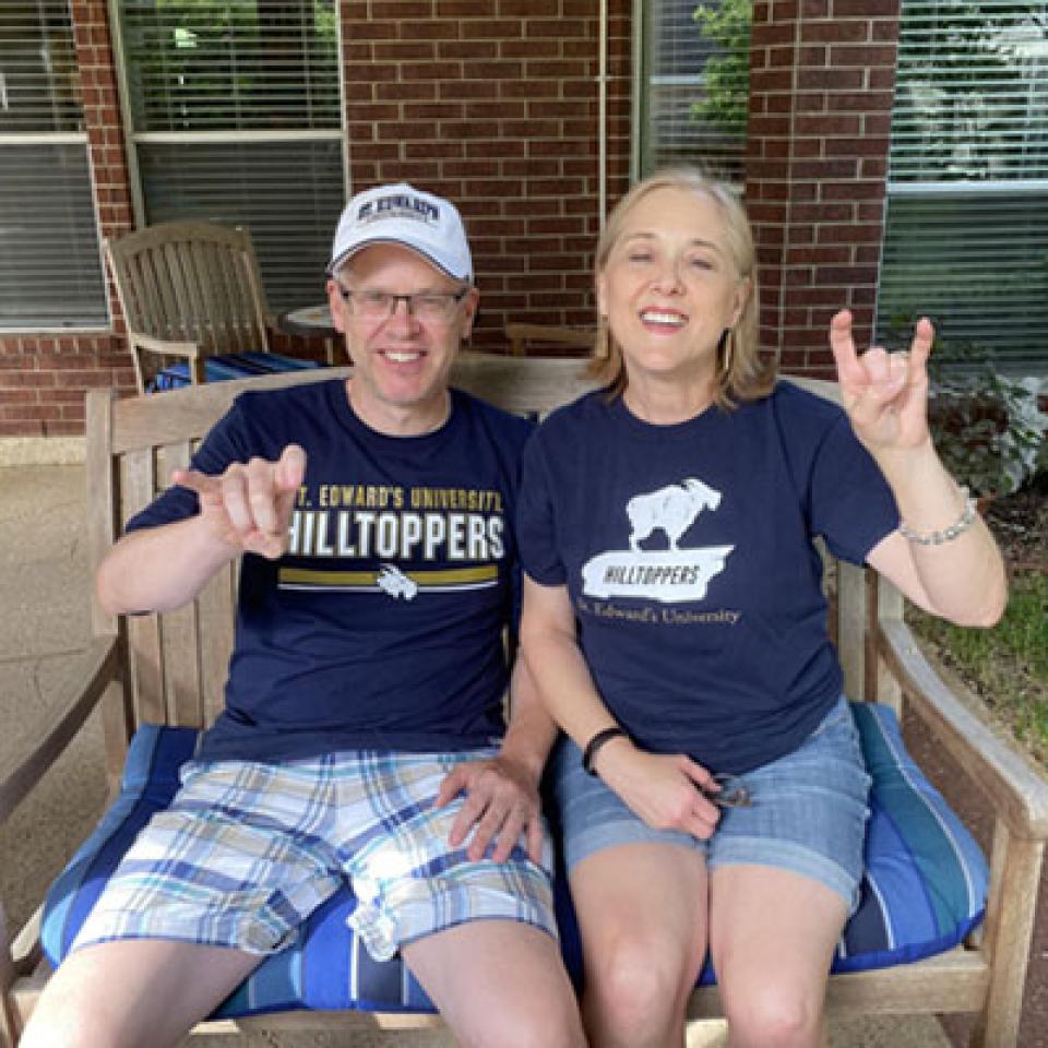 Sammi's parents wear St. Edward's shirts and make toppers up signs on their patio.