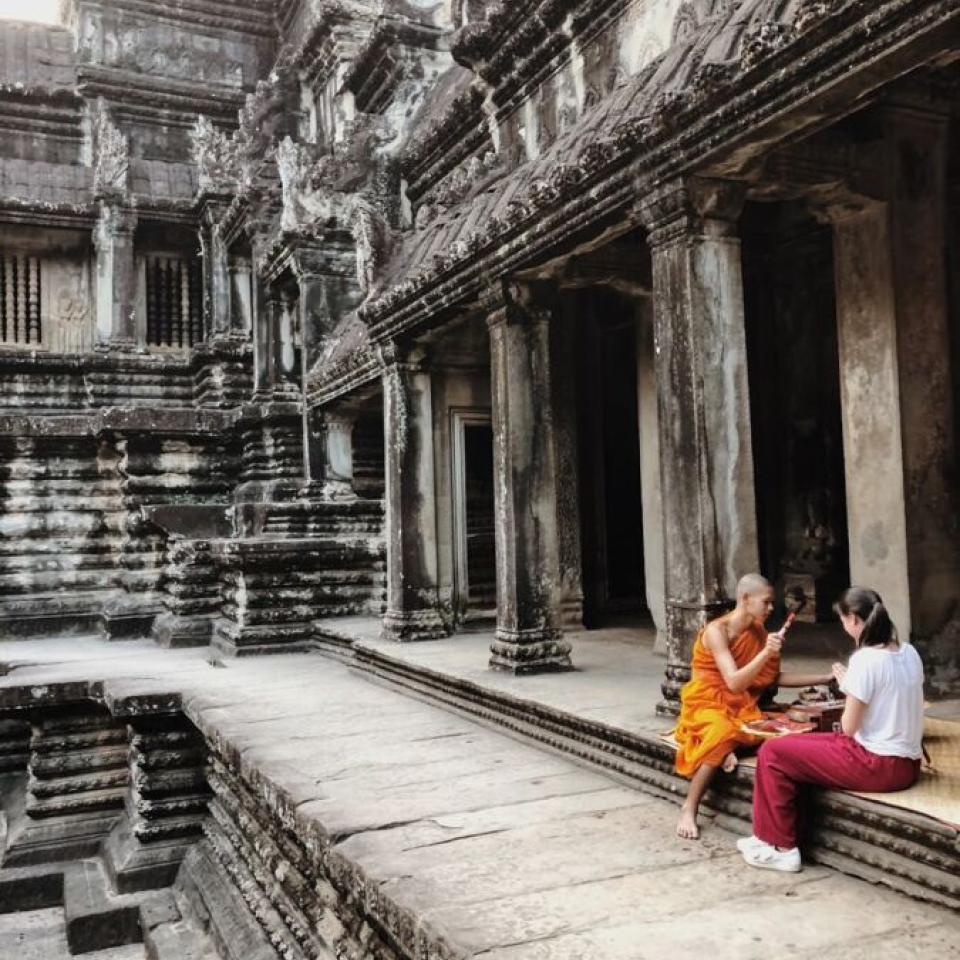 Aida Domingo talks to a monk in a temple.