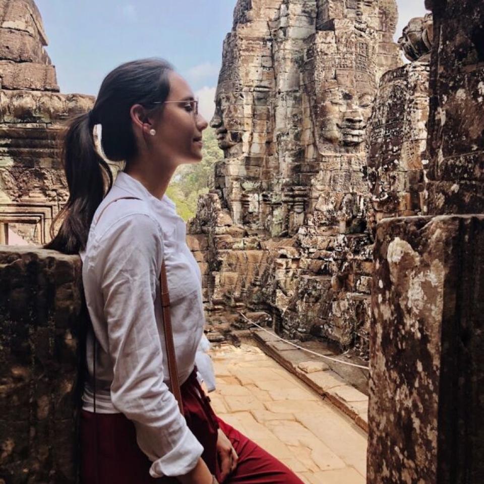 Aida Domingo stands amongst ancient architecture.