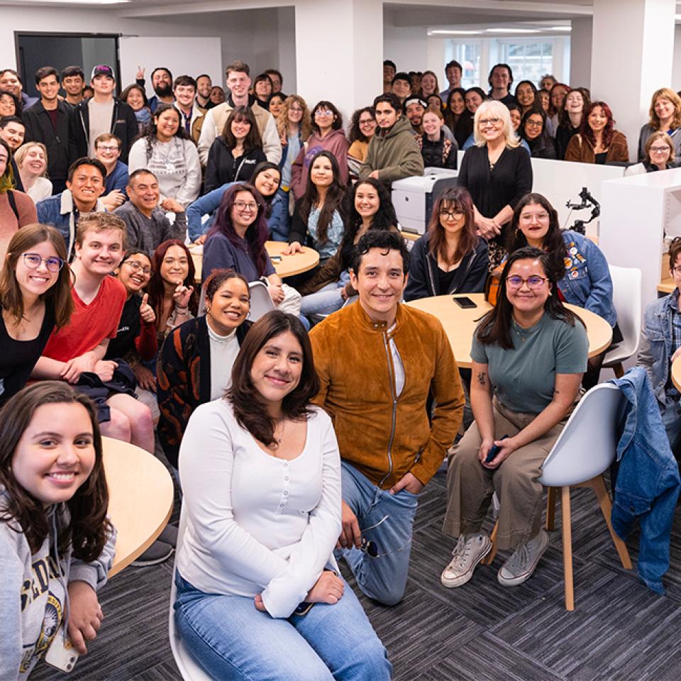 Actor and former student Gabriel Luna posing for a photo with students in the Main Building