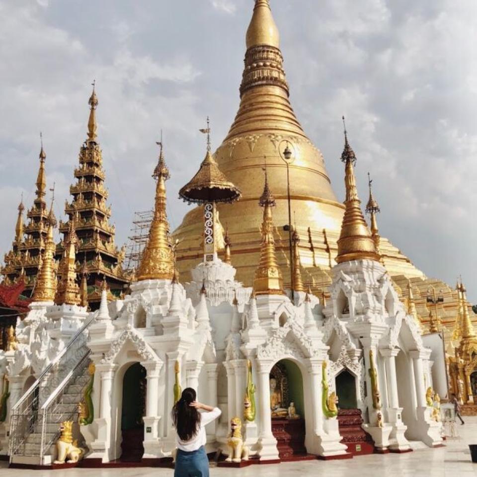 Aida Domingo looks at a white and gold temple.