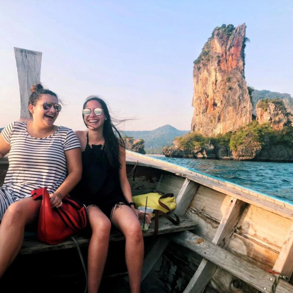 Aida Domingo and a friend ride in a wooden boat.