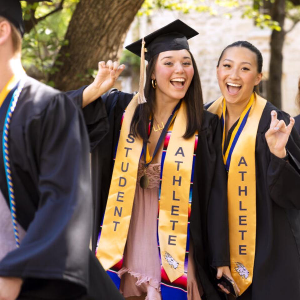 graduates smiling and posing at camera