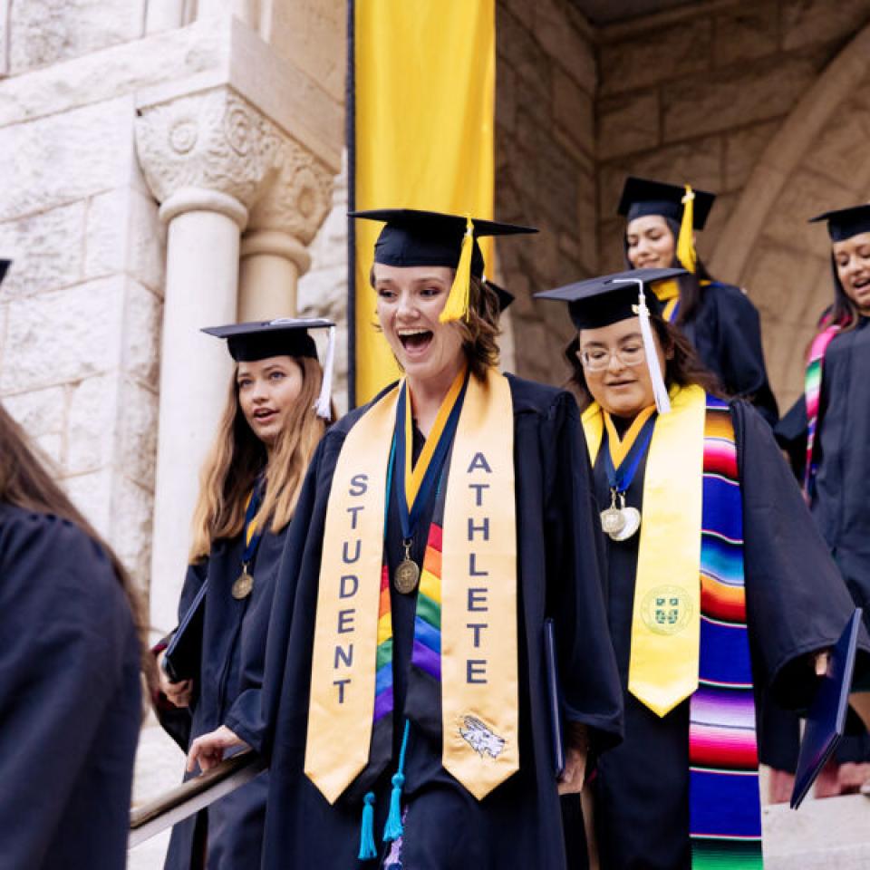 graduates walking out of red doors