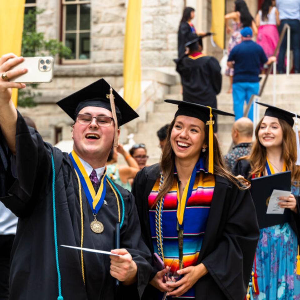 graduates posing for a photo near red doors