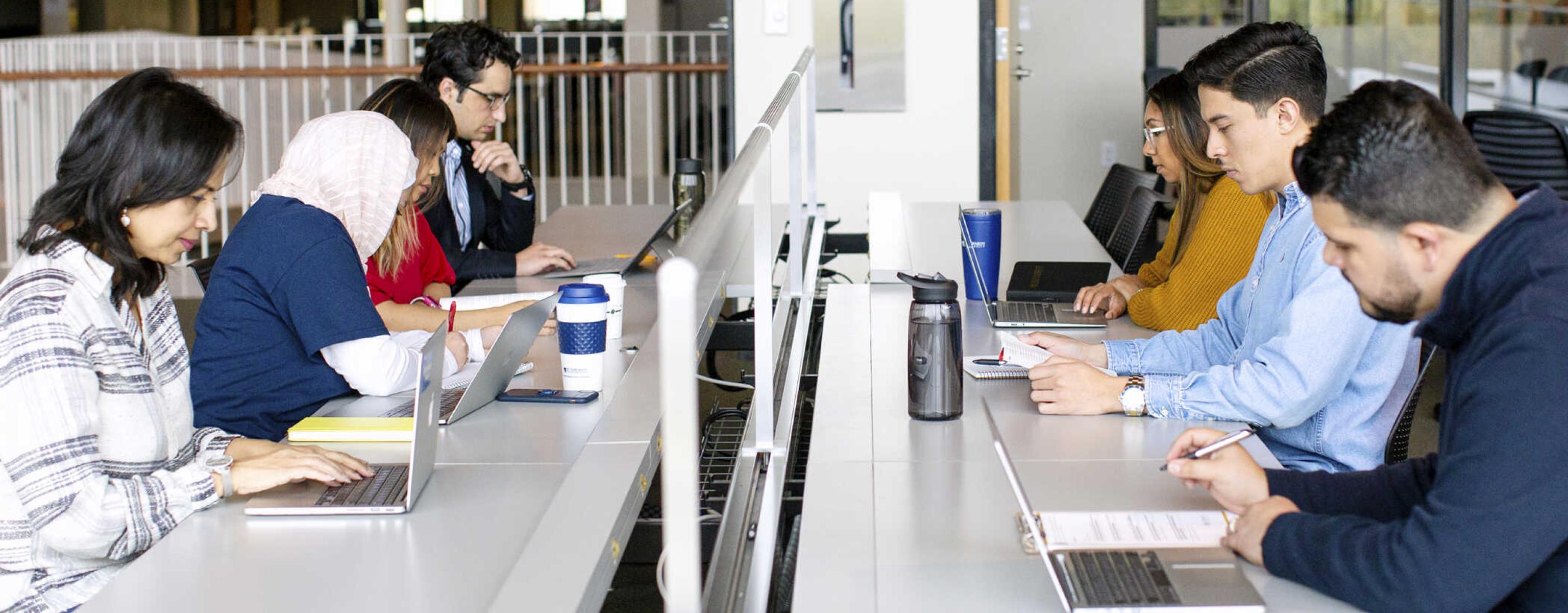 Students working on their laptops in the Munday Library.