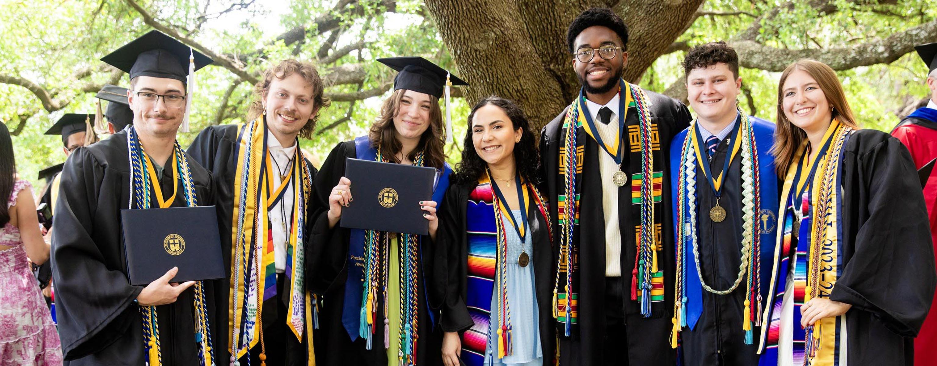 Graduating seniors pose for a group photo in front of Main Building at commencement.