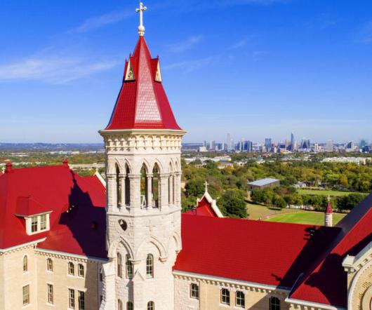 an aerial view of Main Building and the downtown Austin skyline.