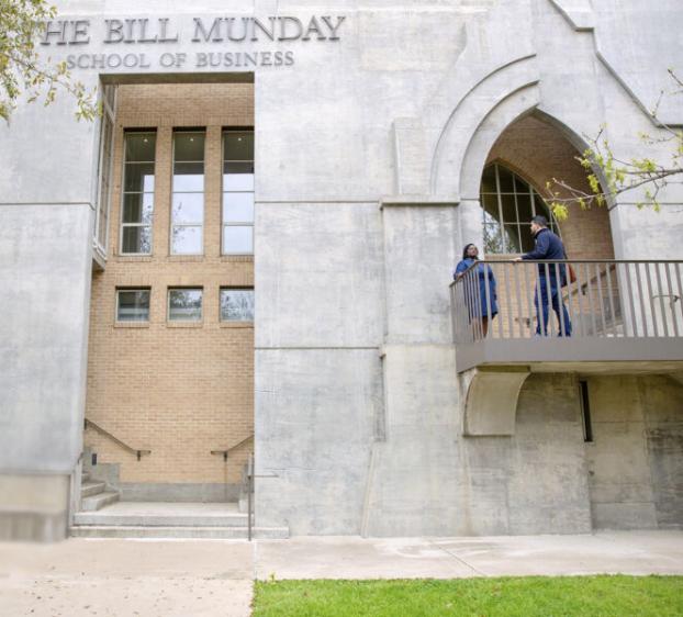 Students talk outside of The Bill Munday School of Business at St. Edward's University