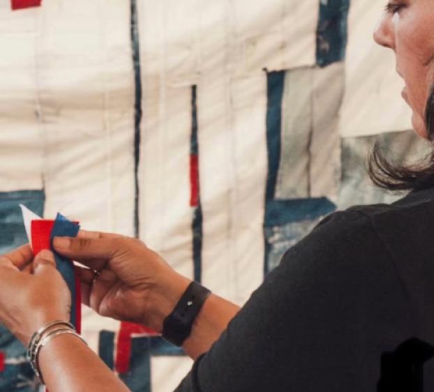 A photo of a woman standing in front of art work