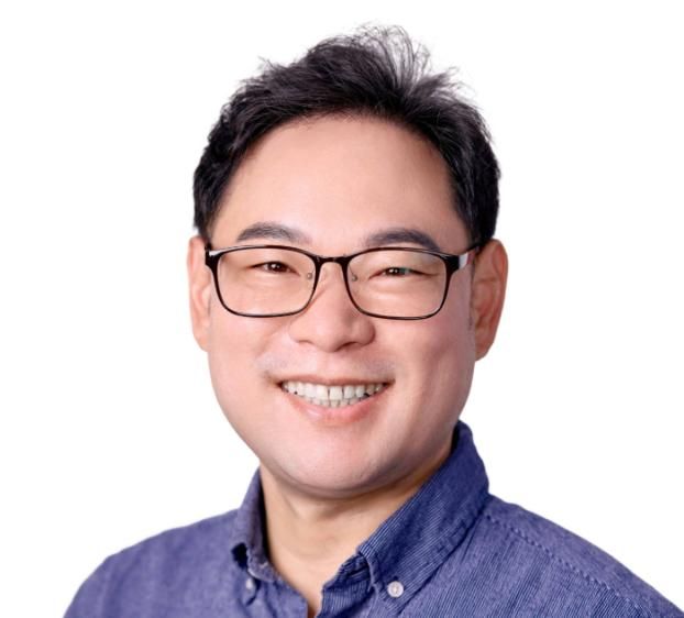closeup of man smiling, with glasses and short dark hair