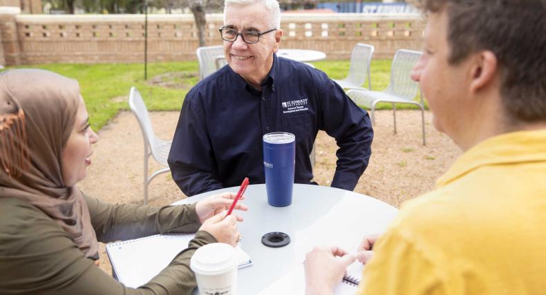 Graduate Professor talking to students outside of class