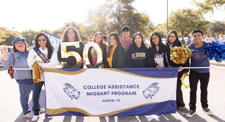 Students holding a College Assistance Migrants Program banner at a parade 