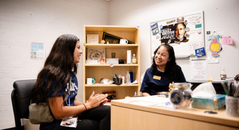 A student meets with a Success Coach in the success coach's office.