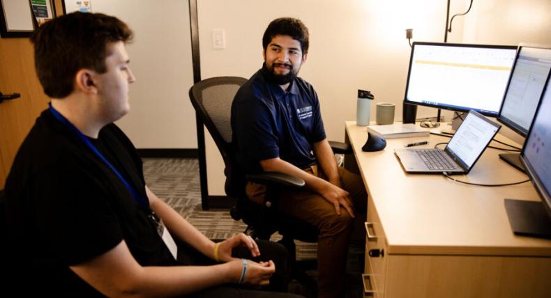 A student meets with a success coach in their office.