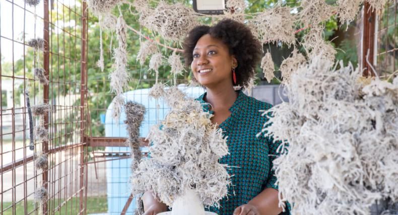 Tammie Rubin stands with her art in an outdoor studio.