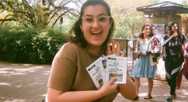 A student holds flyers on campus.