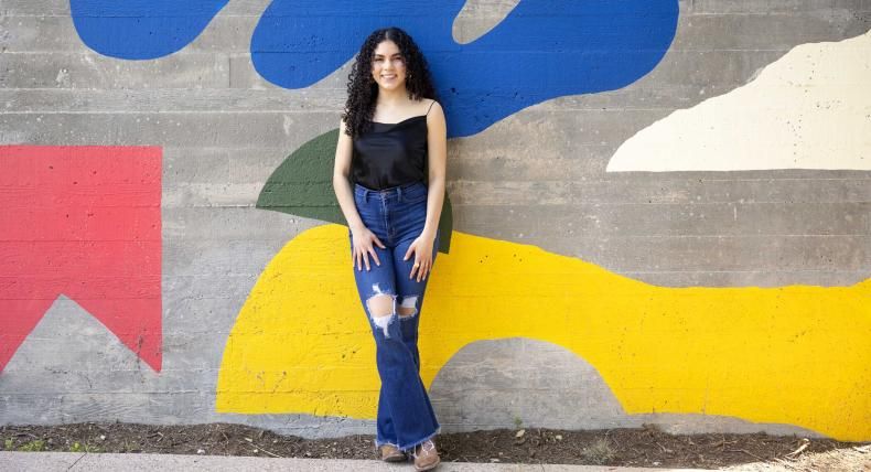 Ruvi Jaimes stands in front of a colorful mural on South Congress.