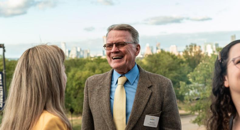 Alumni with a name tag chatting at an event on campus 