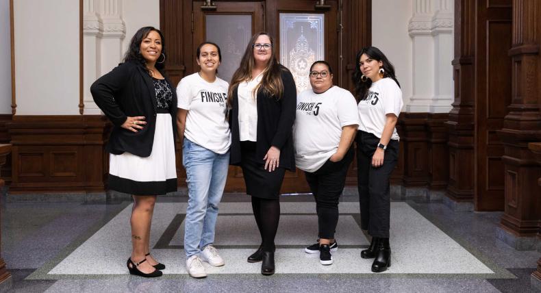 Leah Pinney, center, stands her staff members in the Texas State Capitol.