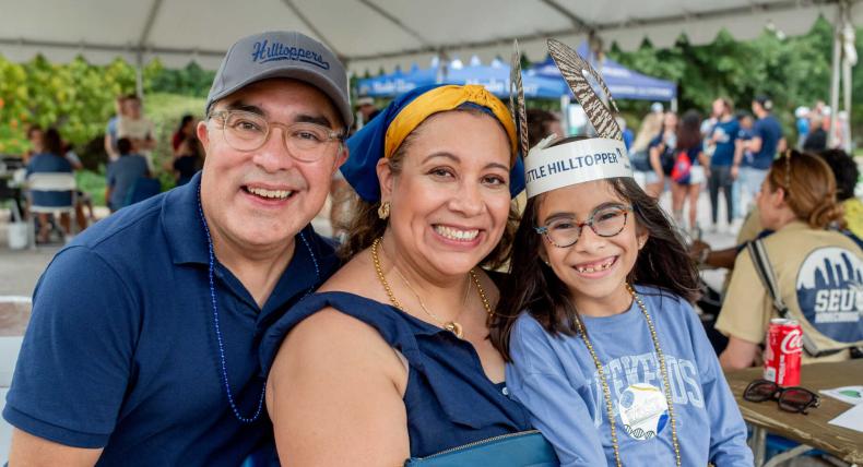 A family wearing blue and gold at homecoming.