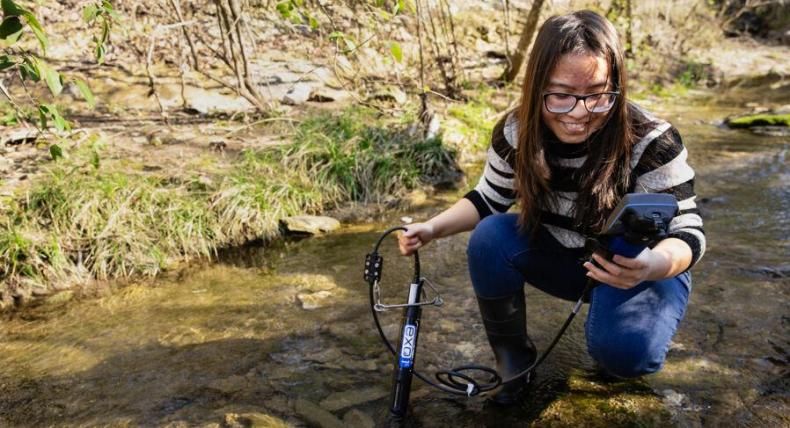 A biology student works in the field