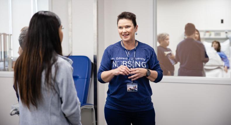 Donna Beuk talks to a student in the nursing labs