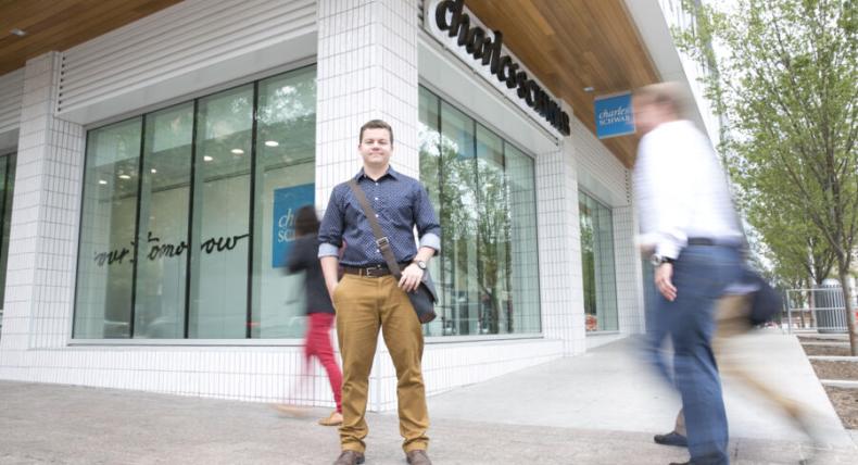 student at a downtown street corner during an internship 