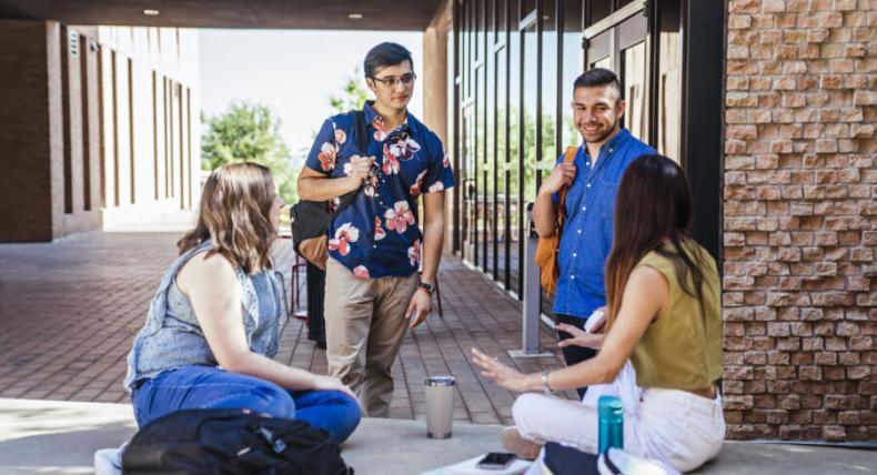 Four students at St. Edward's visit outside the Residential Village 