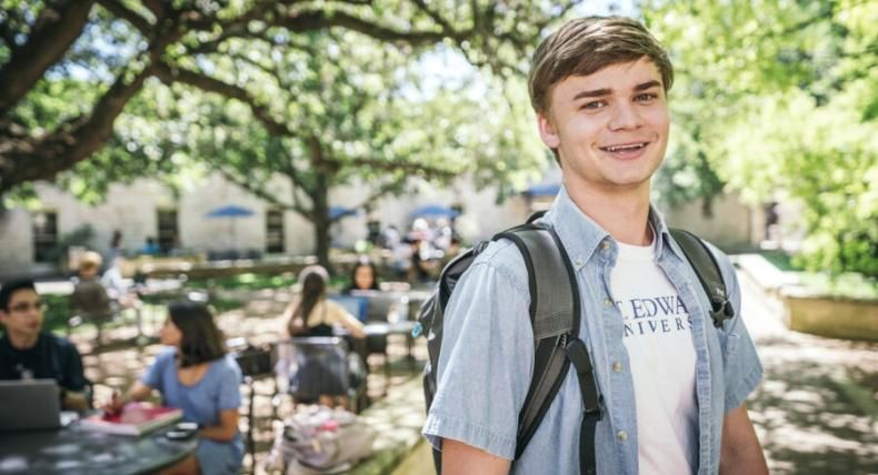 Student with a backpack outside under beautiful trees 