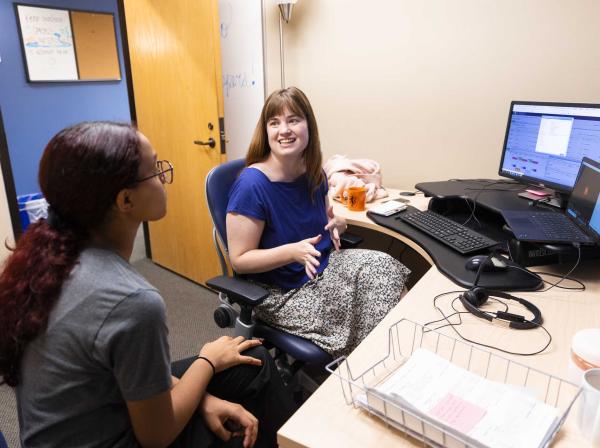 Success coach advises student in university office.