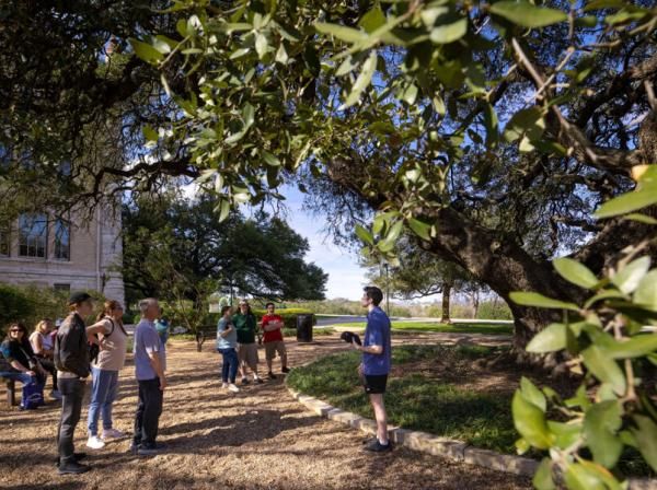 A Hilltop Hospitality student leads a campus tour and chats with guests under Sorin Oak.