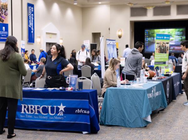 Students interact with employers tabling at a job fair.